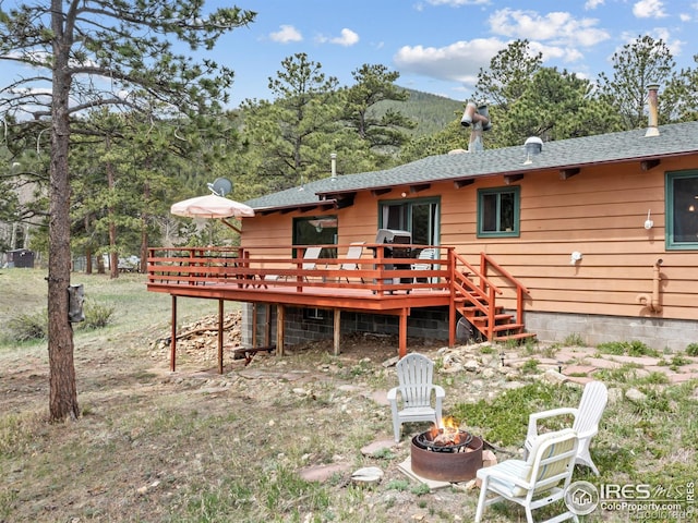 839 Ski Rd, Allenspark, CO 80510 - rear view of house with a wooden deck, an outdoor fire pit, and a shingled roof