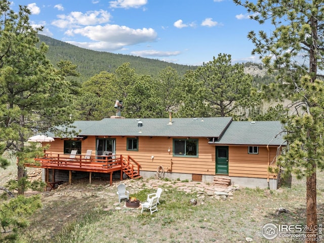 839 Ski Rd, Allenspark, CO 80510 - back of property with a forest view, a deck, and a shingled roof