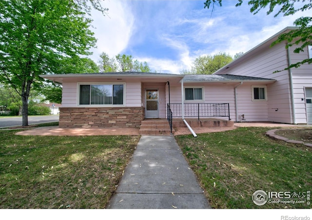 201 Howard St, Brush, CO 80723 - view of front of home featuring a front yard and stone siding