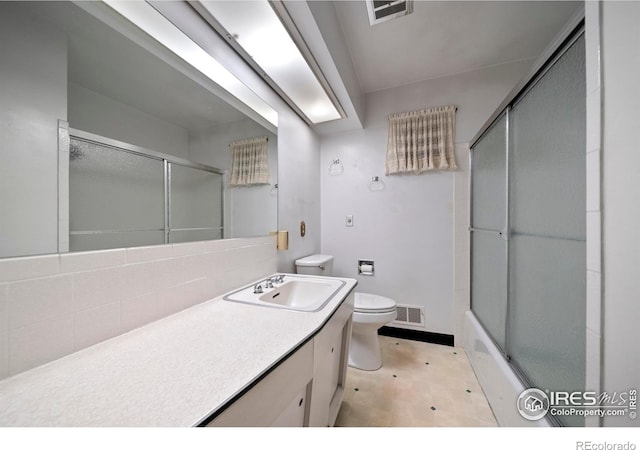 201 Howard St, Brush, CO 80723 - bathroom with toilet, vanity, tile patterned floors, enclosed tub / shower combo, and tasteful backsplash