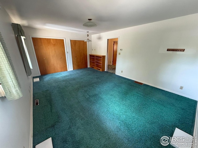 201 Howard St, Brush, CO 80723 - unfurnished bedroom with multiple closets, carpet flooring, and baseboards