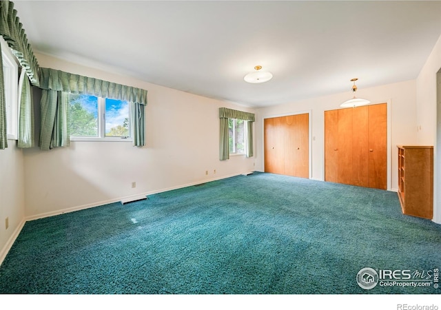 201 Howard St, Brush, CO 80723 - unfurnished bedroom with carpet flooring, two closets, and baseboards