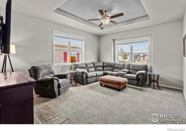 6150 Bluestem Grn, Frederick, CO 80530 - carpeted living room featuring a tray ceiling, ceiling fan, and baseboards