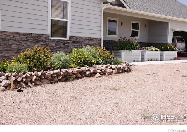 631 Linecamp Dr, Livermore, CO 80536 - view of property exterior featuring stone siding, an attached garage, and roof with shingles