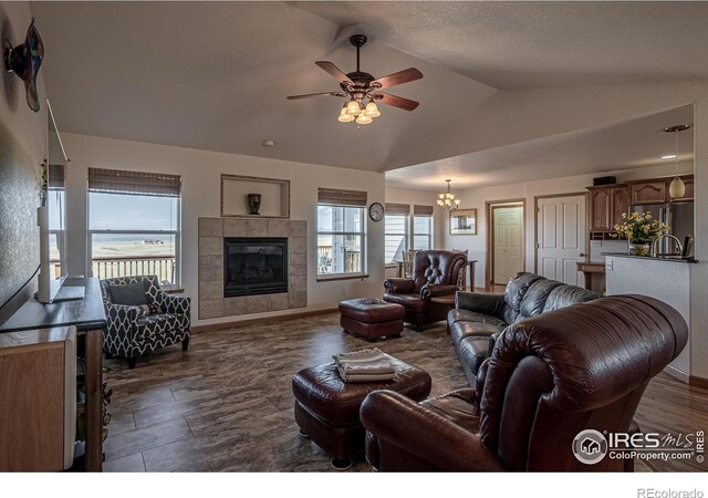 631 Linecamp Dr, Livermore, CO 80536 - living area featuring lofted ceiling, a ceiling fan, baseboards, a chandelier, and a tile fireplace