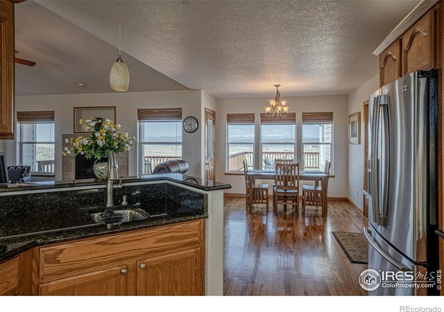 631 Linecamp Dr, Livermore, CO 80536 - kitchen featuring stainless steel fridge with ice dispenser, wood finished floors, a chandelier, a sink, and a textured ceiling