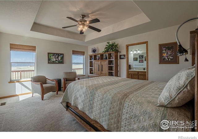 631 Linecamp Dr, Livermore, CO 80536 - carpeted bedroom with a tray ceiling, multiple windows, baseboards, and a ceiling fan
