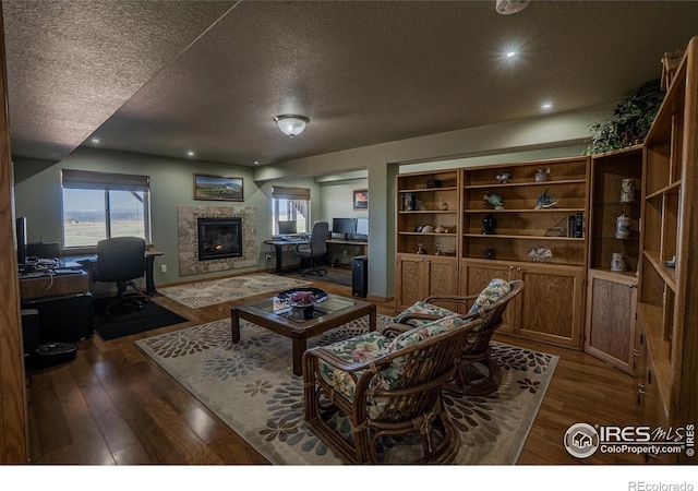 631 Linecamp Dr, Livermore, CO 80536 - living area with a textured ceiling, a desk, a glass covered fireplace, wood finished floors, and baseboards
