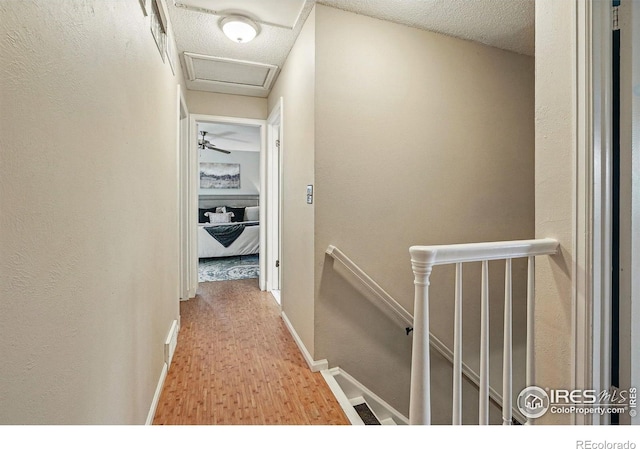 1359 Caledonia Cir, Louisville, CO 80027 - hall with an upstairs landing, attic access, wood finished floors, and baseboards