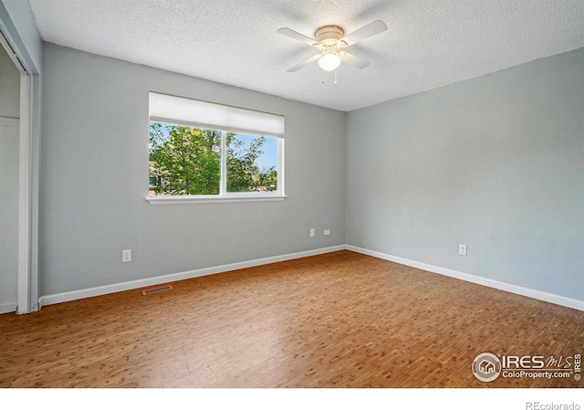 1359 Caledonia Cir, Louisville, CO 80027 - unfurnished bedroom featuring wood finished floors, a textured ceiling, baseboards, a closet, and a ceiling fan