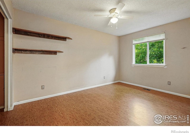 1359 Caledonia Cir, Louisville, CO 80027 - empty room with wood finished floors, a ceiling fan, a textured ceiling, and baseboards