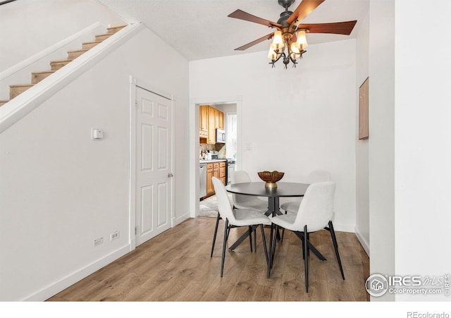 135 E 8th Ave, Denver, CO 80203 - dining space featuring light wood finished floors, a ceiling fan, baseboards, and stairway
