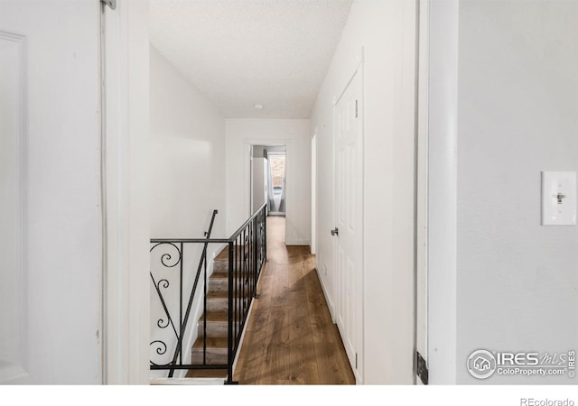 135 E 8th Ave, Denver, CO 80203 - hall featuring wood finished floors, an upstairs landing, and a textured ceiling