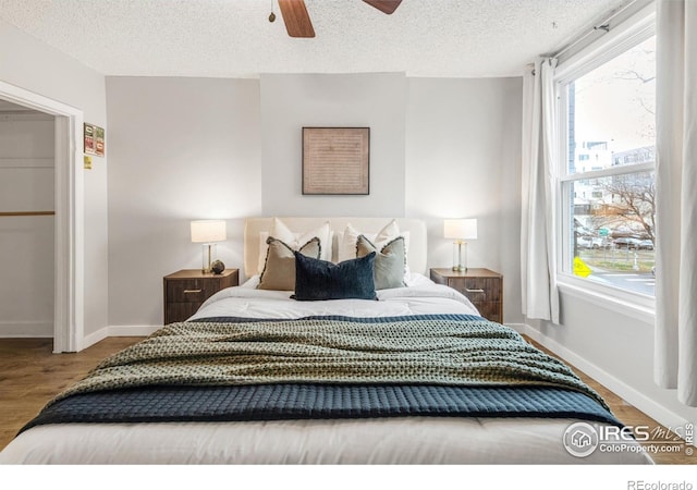 135 E 8th Ave, Denver, CO 80203 - bedroom with wood finished floors, a textured ceiling, baseboards, and ceiling fan