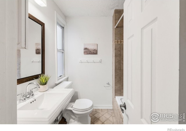 135 E 8th Ave, Denver, CO 80203 - bathroom with toilet, a sink, a textured ceiling, bathtub / shower combination, and tile patterned floors