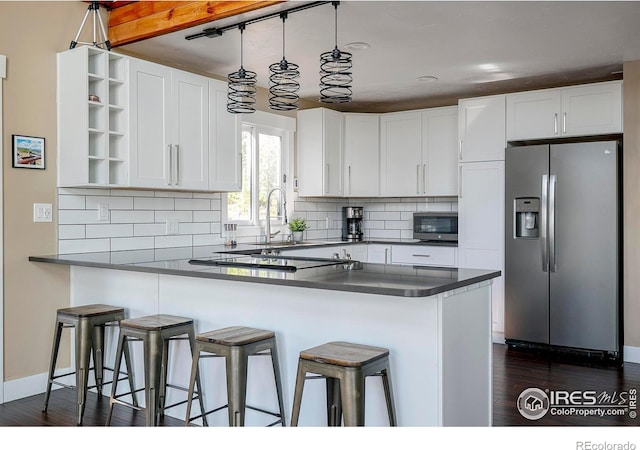 61 County Road 8501, Tabernash, CO 80478 - kitchen featuring stainless steel appliances, open shelves, dark countertops, a sink, and a peninsula