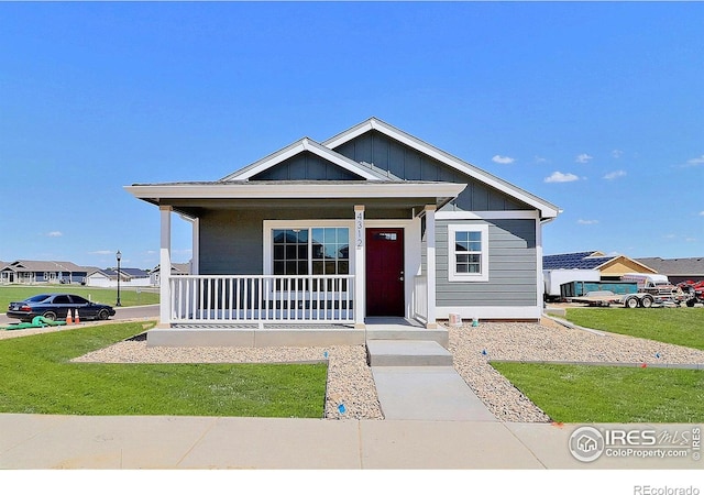 4312 Rockcress Rd, Evans, CO 80620 - view of front of property with a porch, board and batten siding, and a front lawn