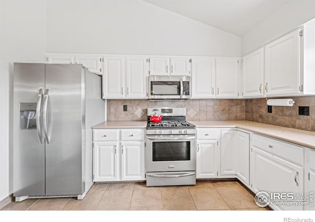 1921 Glenview Ct, Berthoud, CO 80513 - kitchen featuring appliances with stainless steel finishes, backsplash, light countertops, lofted ceiling, and white cabinetry
