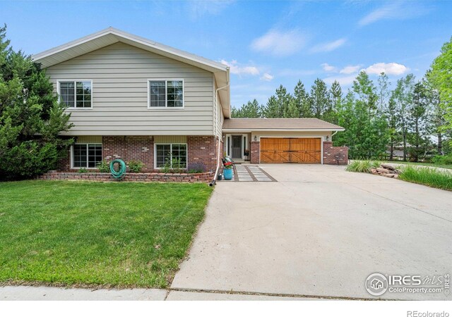 1921 Glenview Ct, Berthoud, CO 80513 - tri-level home featuring brick siding, a garage, concrete driveway, and a front lawn