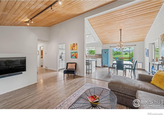 1921 Glenview Ct, Berthoud, CO 80513 - living area featuring rail lighting, wood ceiling, high vaulted ceiling, a chandelier, and light wood-style floors