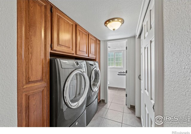 1921 Glenview Ct, Berthoud, CO 80513 - washroom featuring separate washer and dryer, cabinet space, light tile patterned floors, and a textured ceiling