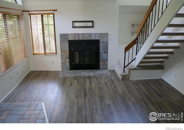 4775 White Rock Cir Unit B, Boulder, CO 80301 - unfurnished living room with wood finished floors, stairs, healthy amount of natural light, and a tiled fireplace