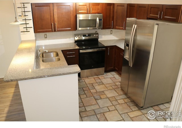 4775 White Rock Cir Unit B, Boulder, CO 80301 - kitchen with appliances with stainless steel finishes, a sink, a peninsula, decorative backsplash, and light stone counters