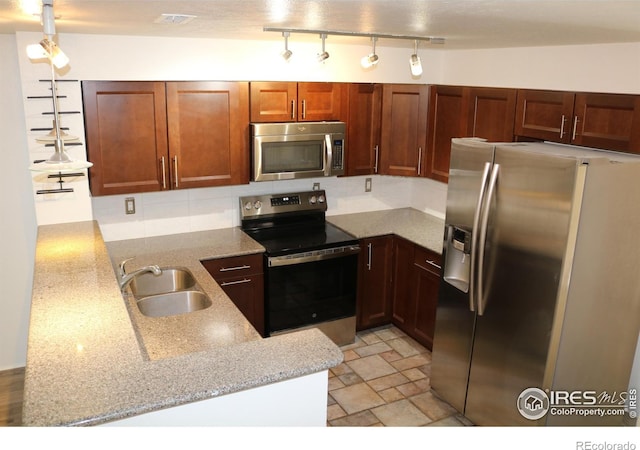 4775 White Rock Cir Unit B, Boulder, CO 80301 - kitchen featuring appliances with stainless steel finishes, a sink, light stone countertops, and a peninsula