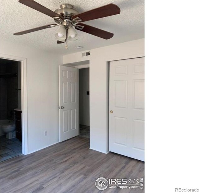 4775 White Rock Cir Unit B, Boulder, CO 80301 - unfurnished bedroom featuring a textured ceiling, wood finished floors, a closet, ensuite bathroom, and ceiling fan