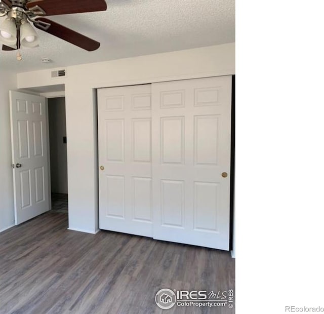 4775 White Rock Cir Unit B, Boulder, CO 80301 - unfurnished bedroom with a closet, dark wood-style floors, a textured ceiling, a ceiling fan, and baseboards