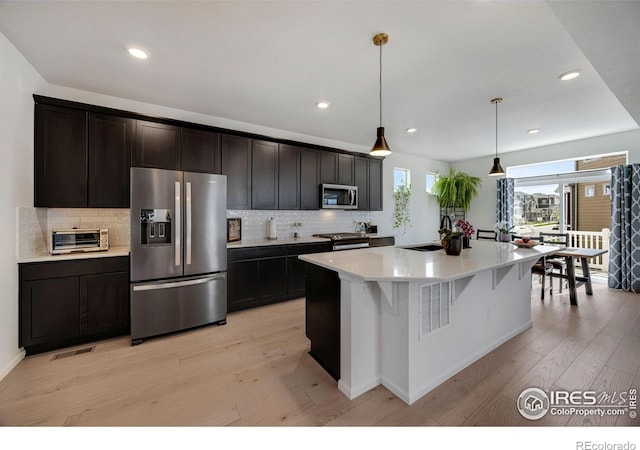 542 Highlands Cir, Erie, CO 80516 - kitchen with stainless steel appliances, light wood-style flooring, decorative backsplash, and recessed lighting