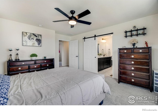 542 Highlands Cir, Erie, CO 80516 - carpeted bedroom featuring a barn door, connected bathroom, and ceiling fan