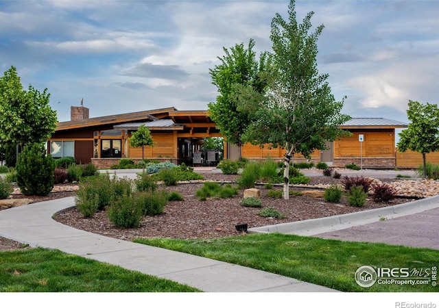 542 Highlands Cir, Erie, CO 80516 - view of front facade featuring stone siding and a chimney