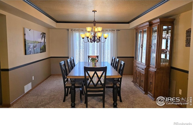 2152 45th Ave, Greeley, CO 80634 - carpeted dining space featuring a chandelier, crown molding, a textured ceiling, and baseboards