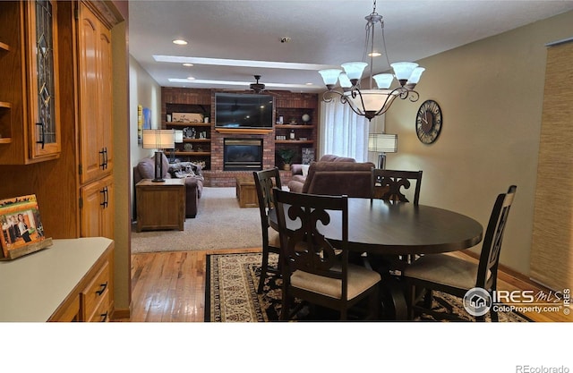 2152 45th Ave, Greeley, CO 80634 - dining area with a brick fireplace, light wood-type flooring, recessed lighting, a chandelier, and ceiling fan