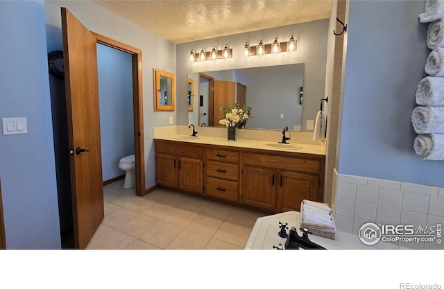 2152 45th Ave, Greeley, CO 80634 - full bathroom featuring double vanity, toilet, tile patterned flooring, and decorative backsplash