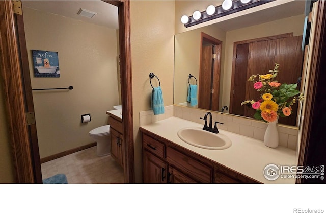 2152 45th Ave, Greeley, CO 80634 - bathroom with vanity, toilet, and baseboards