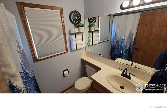 2152 45th Ave, Greeley, CO 80634 - full bath featuring vanity, toilet, a shower with shower curtain, and baseboards