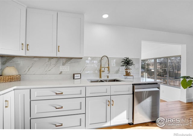 4642 Everett Ct, Wheat Ridge, CO 80033 - kitchen with dishwasher, a sink, light countertops, white cabinets, and tasteful backsplash