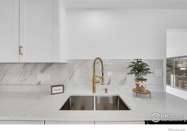 4642 Everett Ct, Wheat Ridge, CO 80033 - kitchen with a sink, light stone countertops, backsplash, and white cabinets