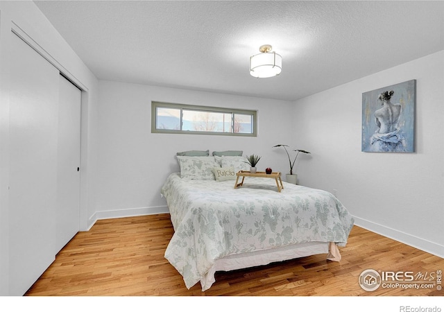 4642 Everett Ct, Wheat Ridge, CO 80033 - bedroom featuring light wood-style floors, a closet, baseboards, and a textured ceiling