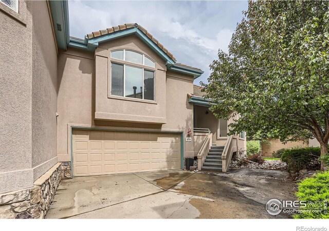 4326 Clay Commons Ct, Boulder, CO 80303 - view of front of house featuring stucco siding, an attached garage, driveway, and a tile roof