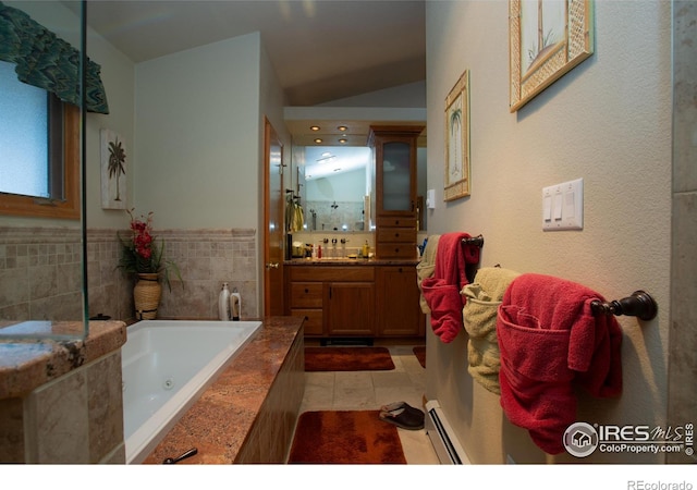1314 State Highway 66, Longmont, CO 80504 - full bathroom with a baseboard radiator, vanity, tile patterned floors, a tub with jets, and vaulted ceiling