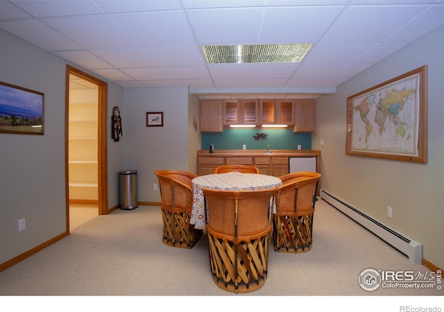 1314 State Highway 66, Longmont, CO 80504 - dining space with a baseboard heating unit, carpet flooring, bar with sink, a drop ceiling, and baseboards