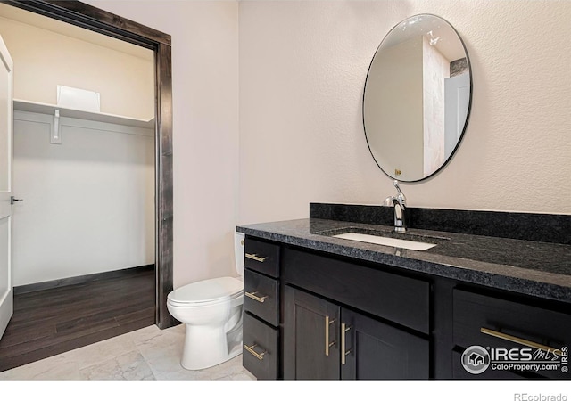 1768 Wildfire Rd Unit 101, Estes Park, CO 80517 - bathroom featuring vanity, toilet, and marble look tile flooring