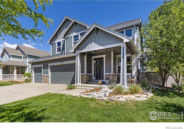 2620 Brush Creek Dr, Fort Collins, CO 80528 - craftsman-style home featuring a garage, covered porch, stone siding, and driveway