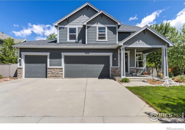 2620 Brush Creek Dr, Fort Collins, CO 80528 - craftsman-style house with covered porch, stone siding, concrete driveway, and a garage
