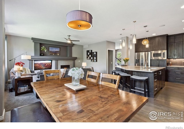 2620 Brush Creek Dr, Fort Collins, CO 80528 - dining space with a tile fireplace, a ceiling fan, dark wood-type flooring, and recessed lighting