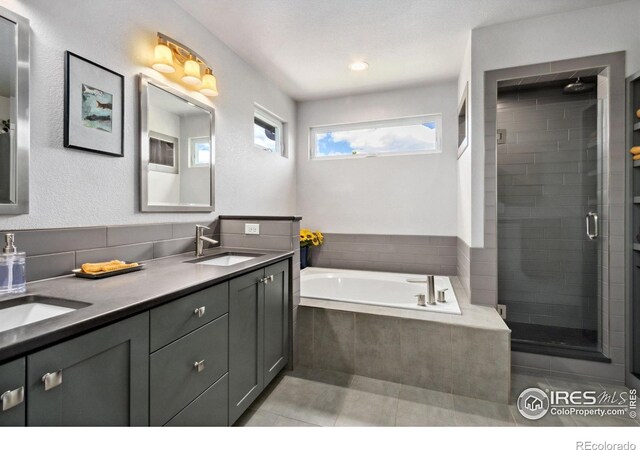 2620 Brush Creek Dr, Fort Collins, CO 80528 - bathroom featuring double vanity, a shower stall, a garden tub, and tile patterned flooring