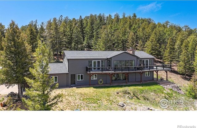 1100 Deer Trail Rd, Boulder, CO 80302 - back of property featuring a deck, a forest view, and a yard